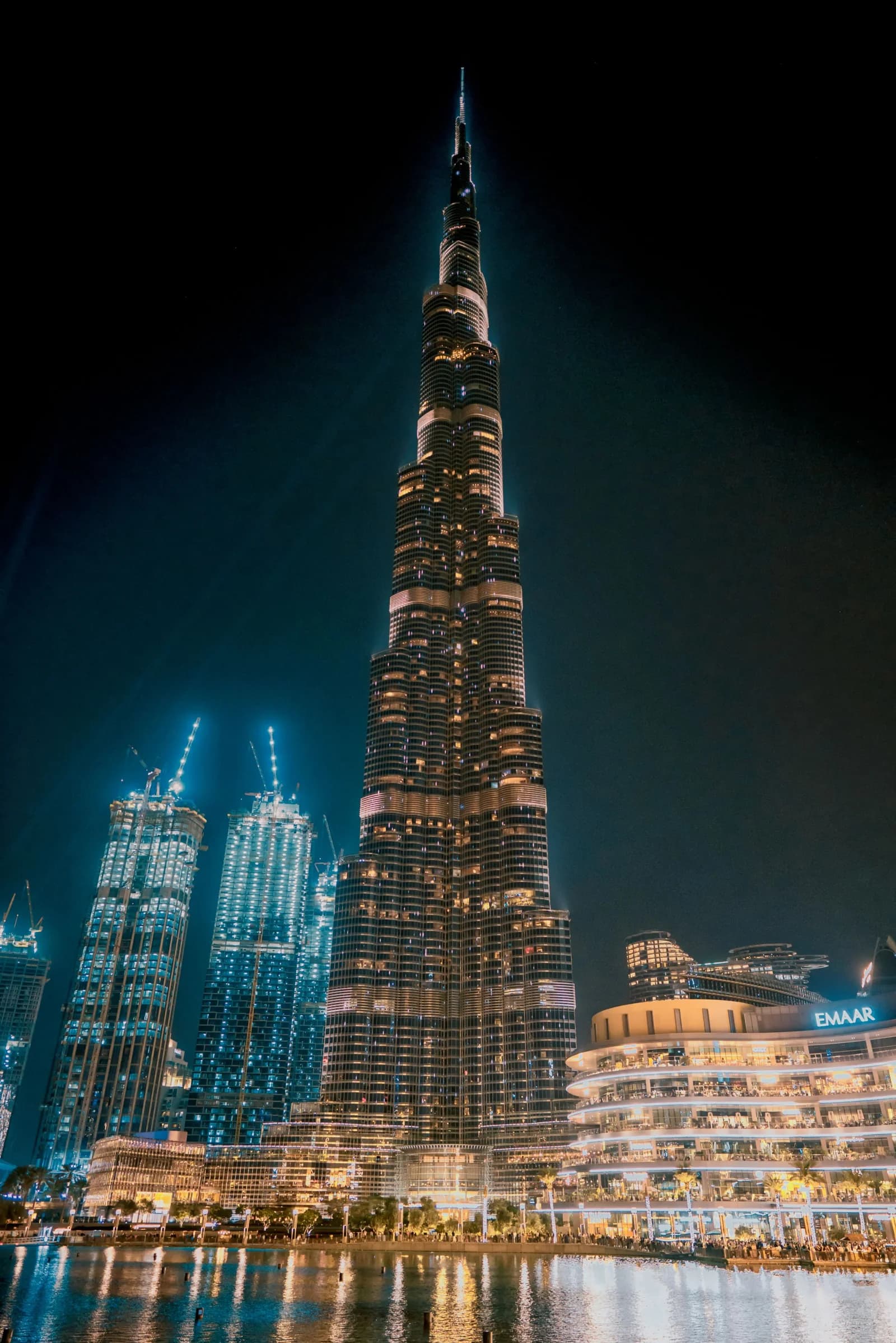 The illuminated Burj Khalifa rising above Downtown Dubai and the waterfront at night